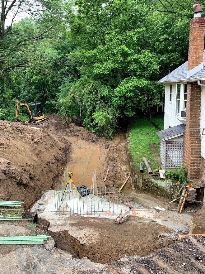 A large hole in the ground in front of a house.
