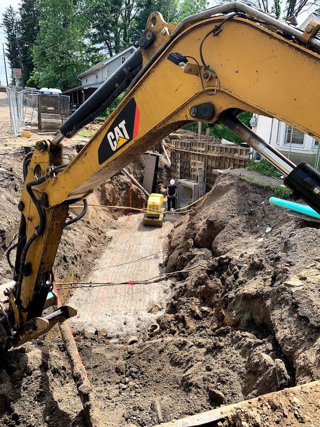 A cat excavator is digging a hole in the ground.