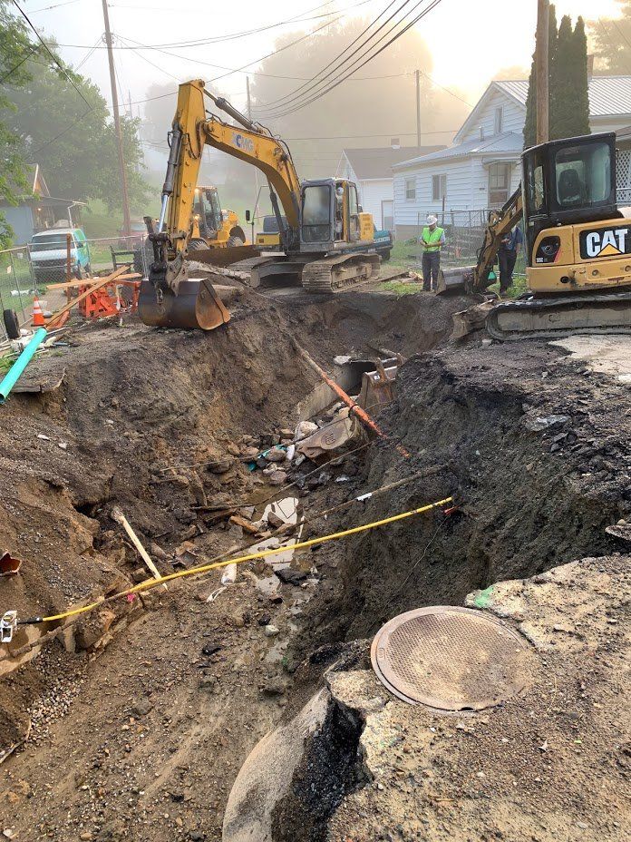 A group of construction workers are digging a hole in the ground.