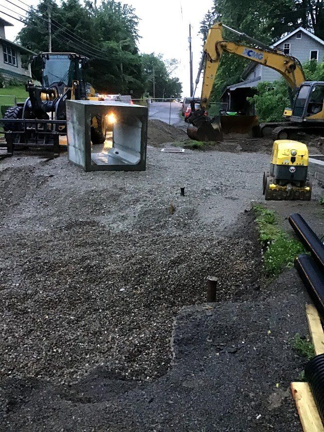 A group of construction vehicles are working on a road.