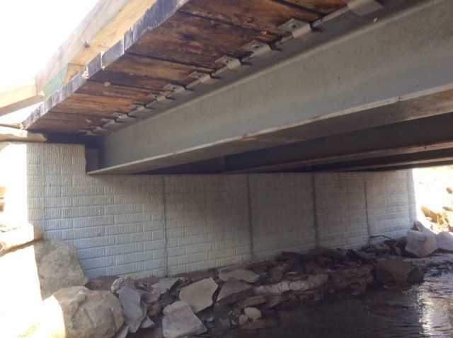 The underside of a bridge with a wooden deck