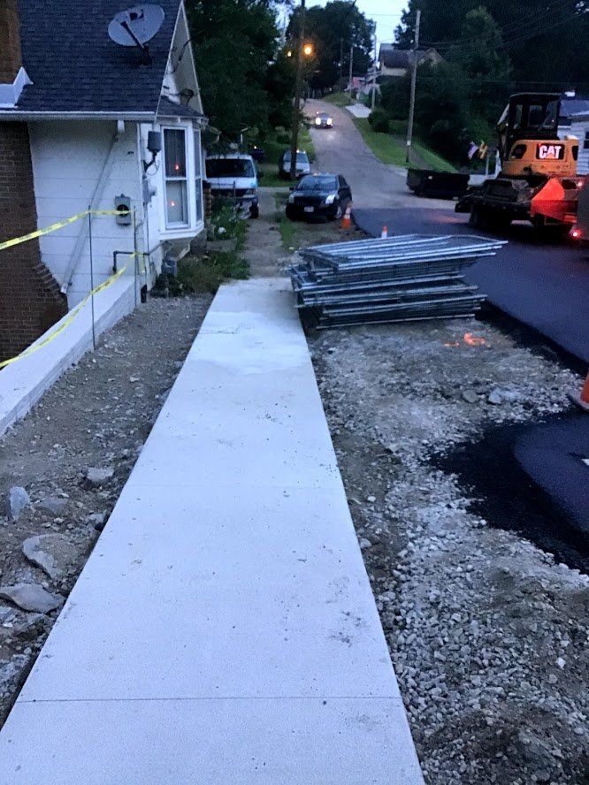 A concrete walkway is being built in front of a house