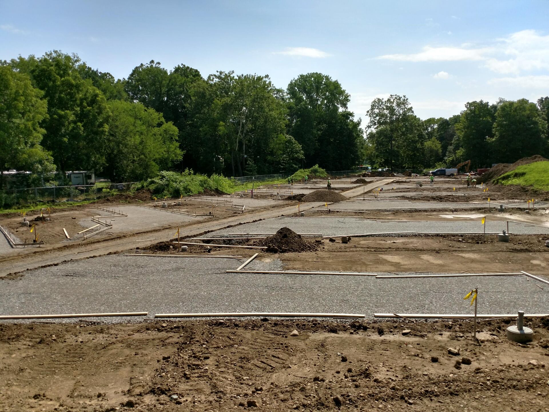 A construction site with a lot of dirt and trees in the background