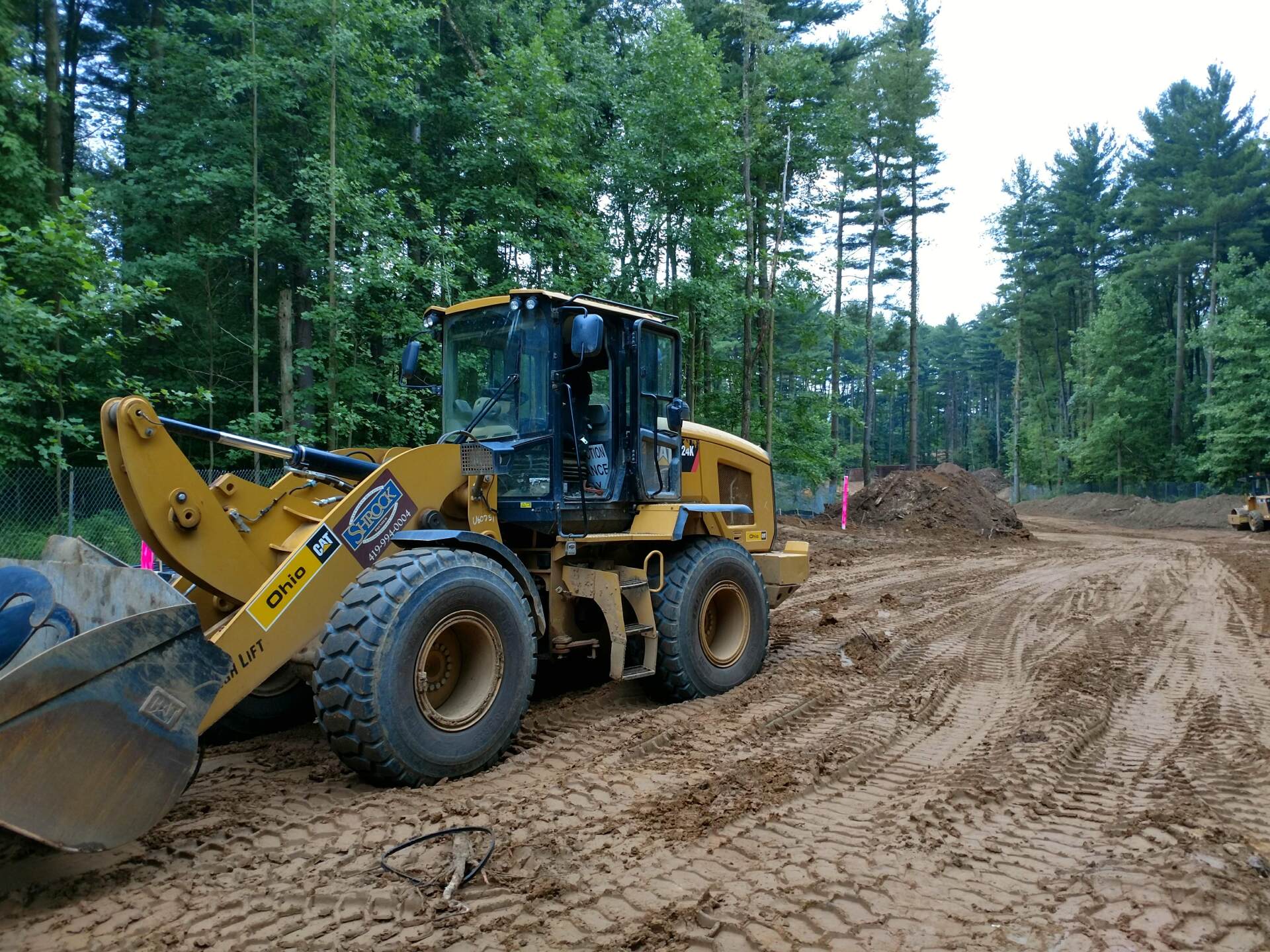 A bulldozer is sitting in the middle of a dirt field.