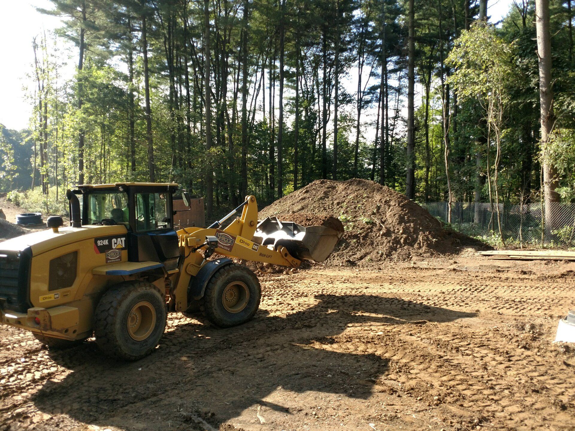 A bulldozer is sitting in a dirt field next to a pile of dirt.