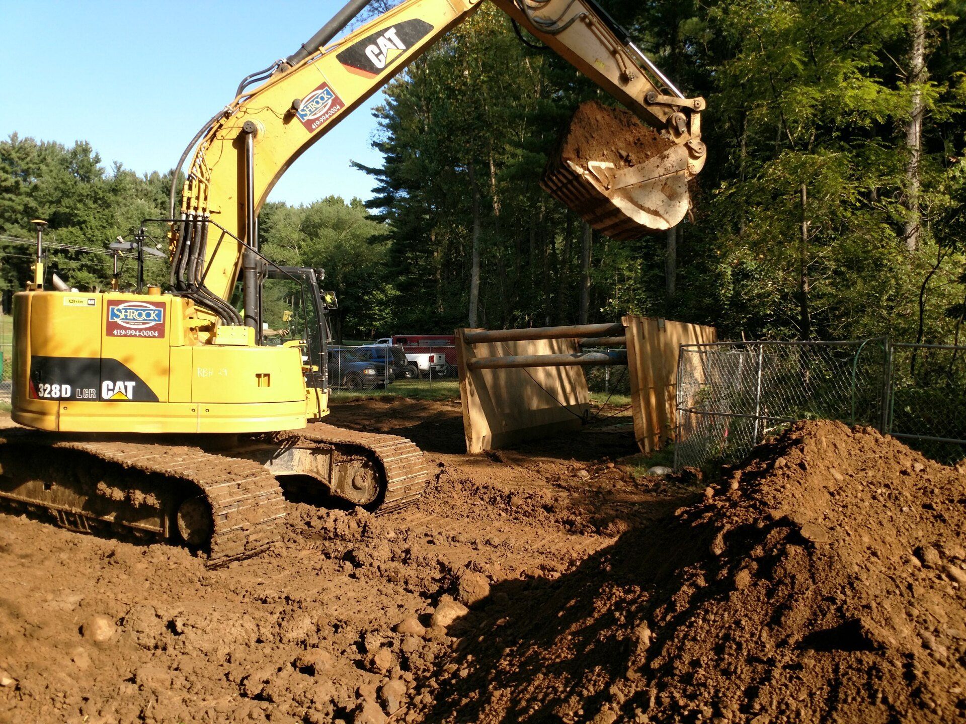 A yellow cat excavator is digging in a pile of dirt