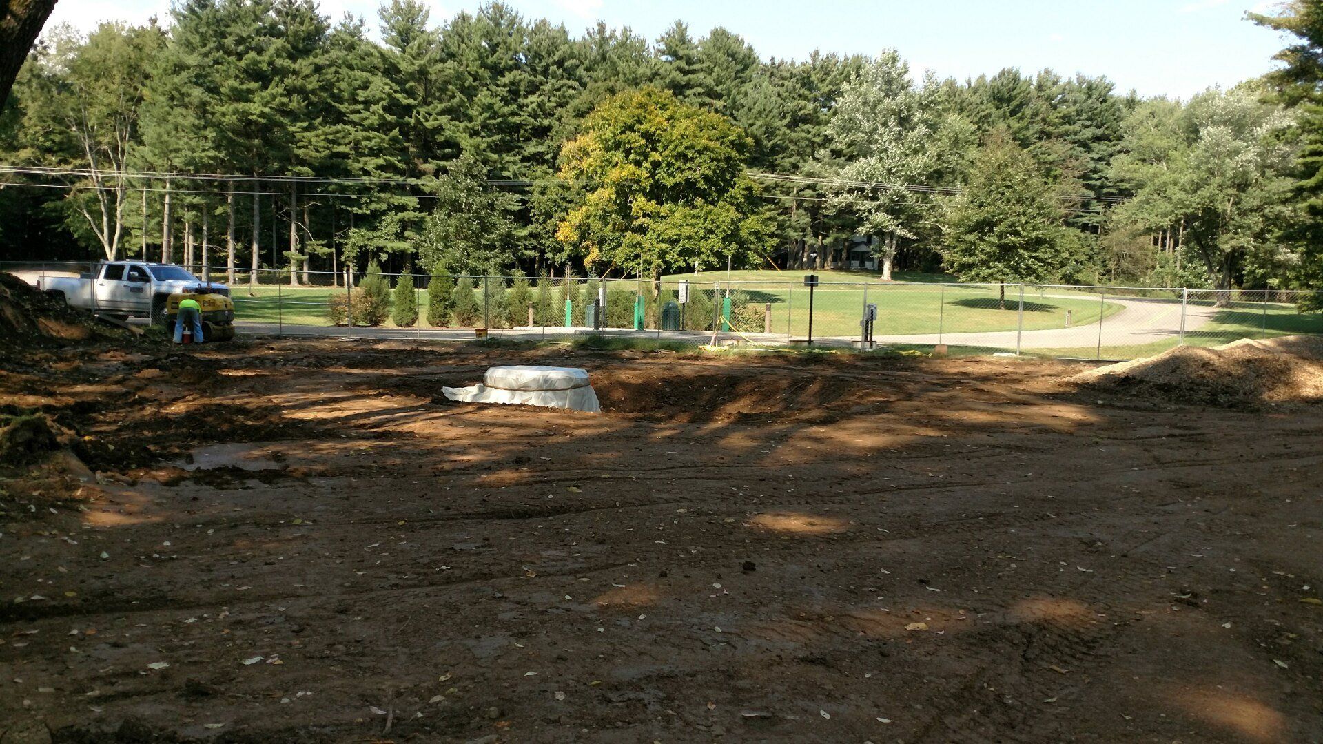 A large dirt field with trees in the background