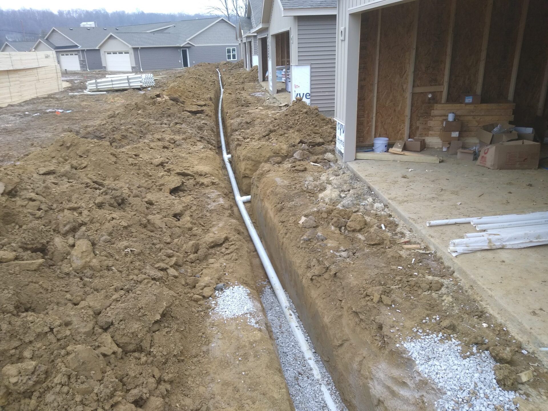 A drainage system is being installed on the side of a house