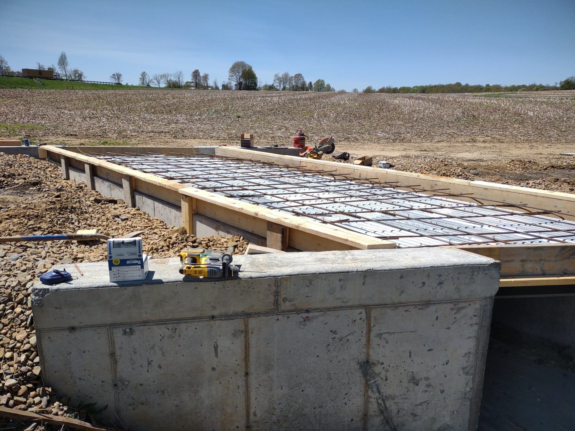 A measuring tape sits on a concrete block in a field