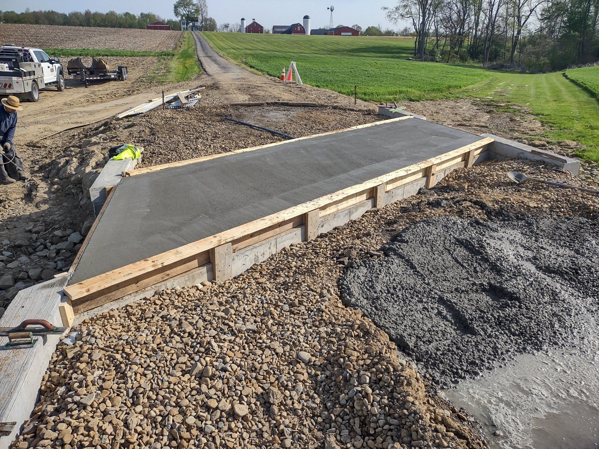 A concrete walkway is being built on a gravel road.