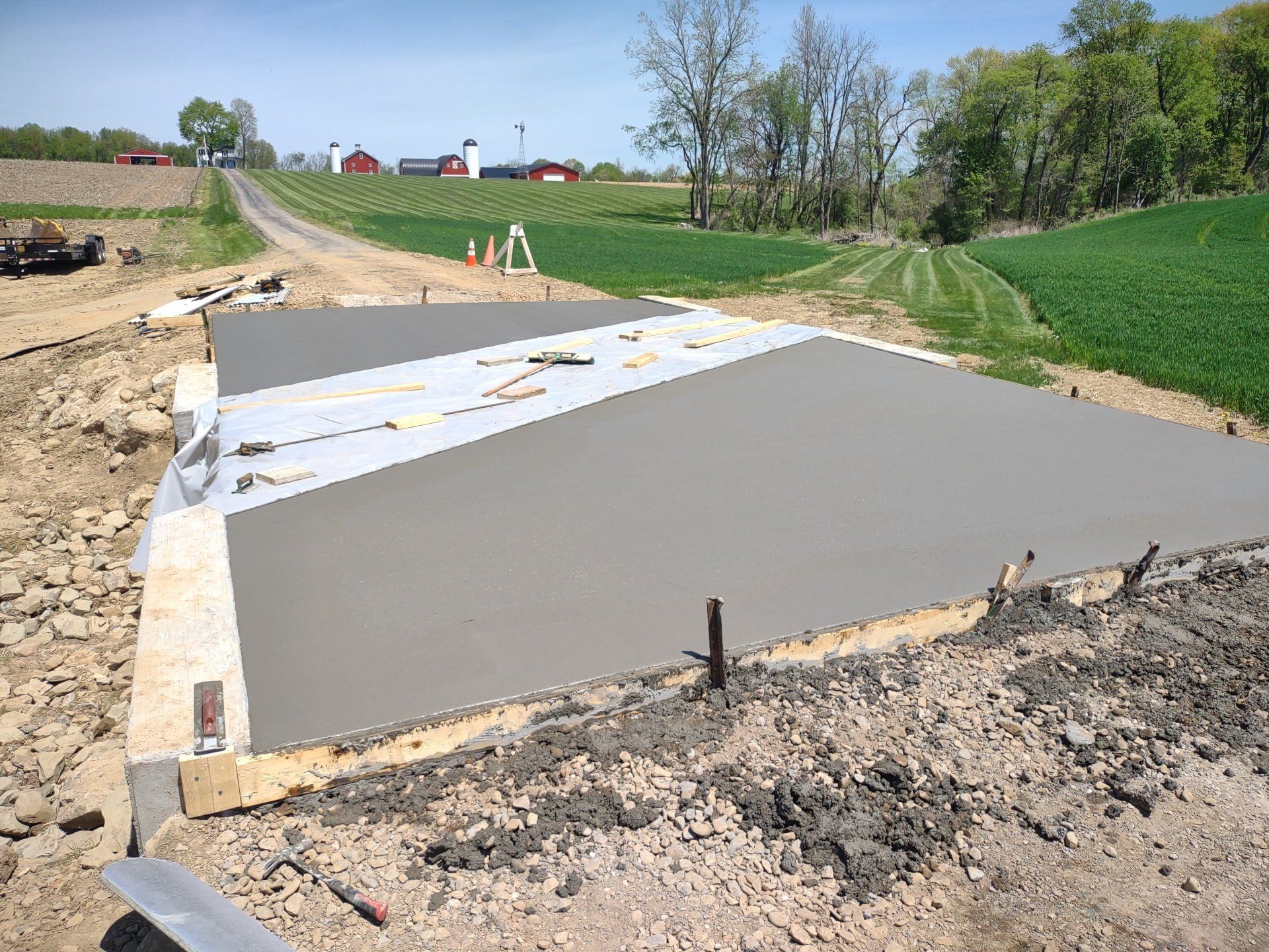 A concrete driveway is being built in the middle of a field.