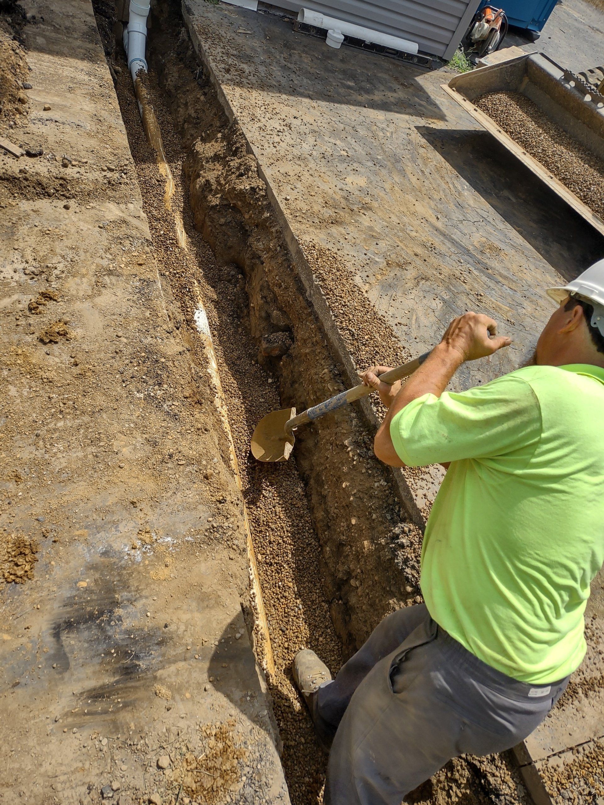 Shrock Excavating team member is digging out the pipe passage way.