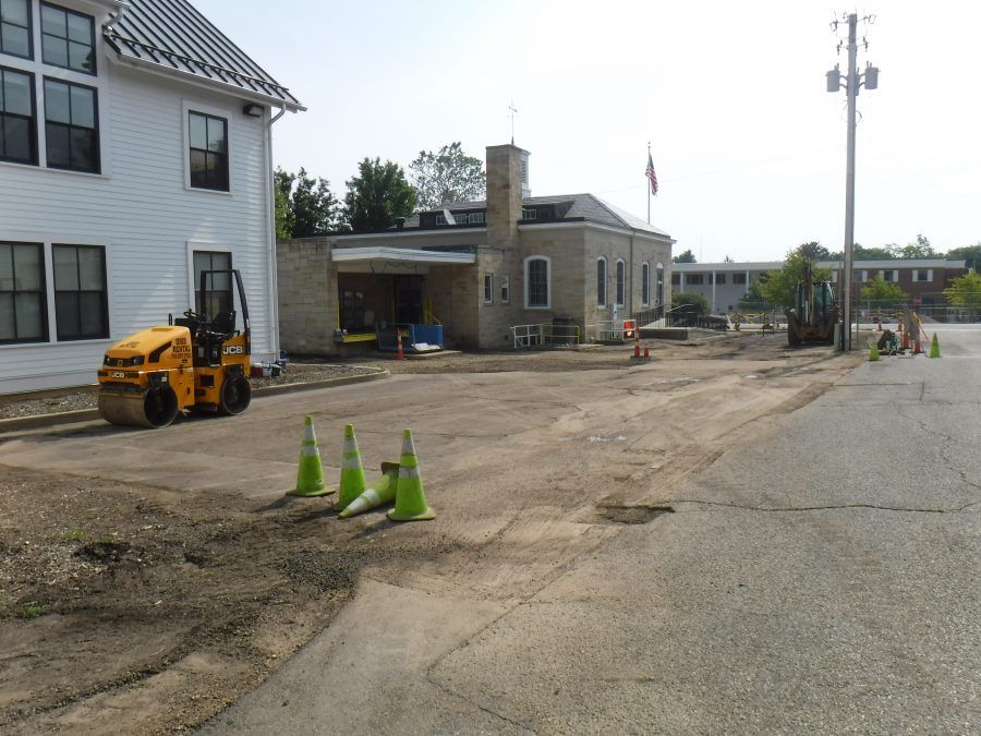 A yellow roller is in the middle of a dirt road