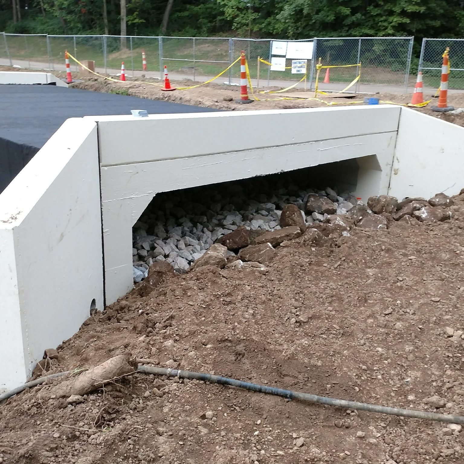 A construction site with a white wall and a hole in the ground