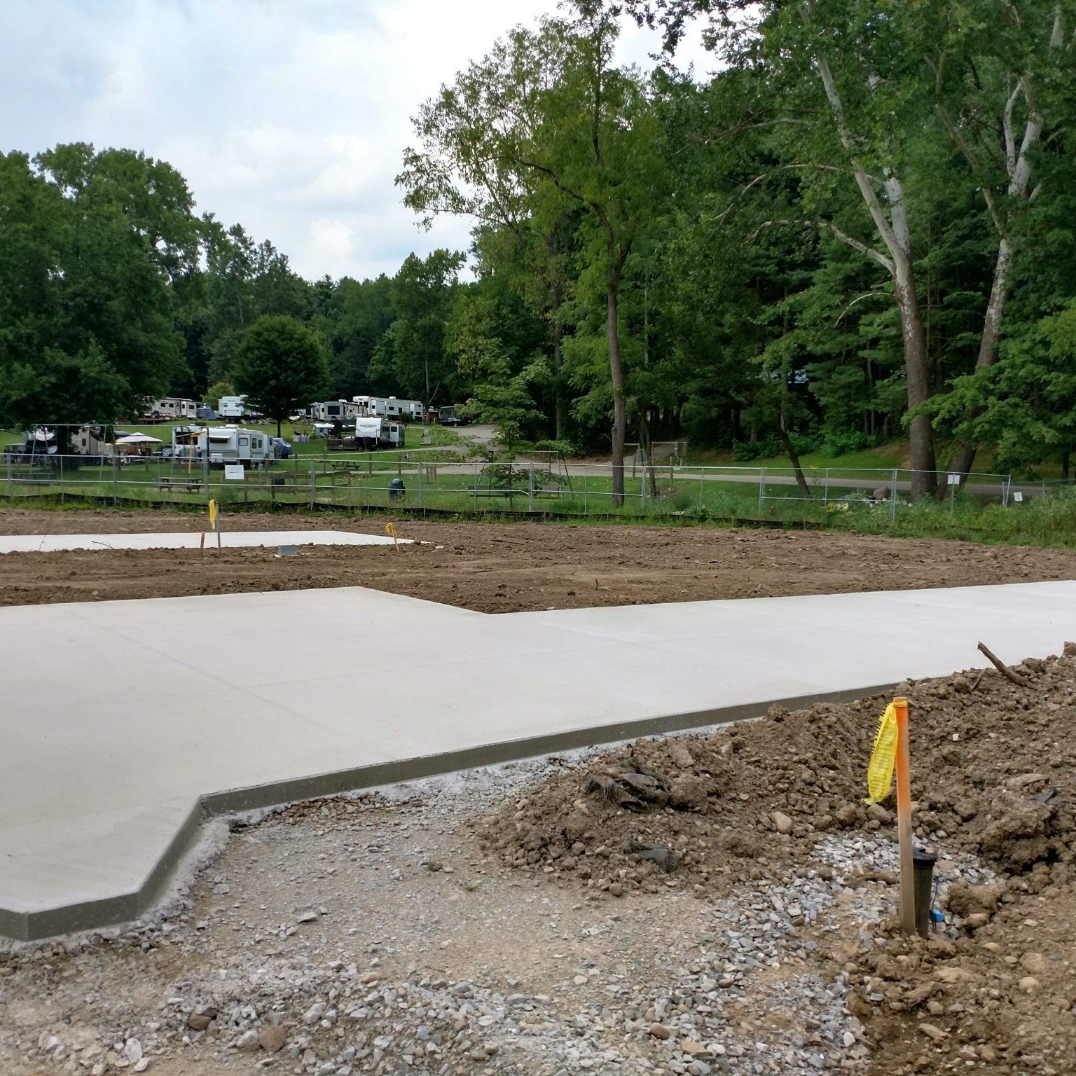 A construction site with a lot of dirt and trees in the background