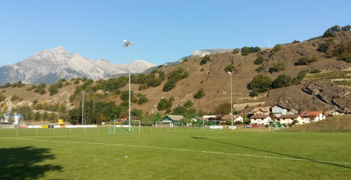Un terrain de football avec une montagne en arrière-plan.