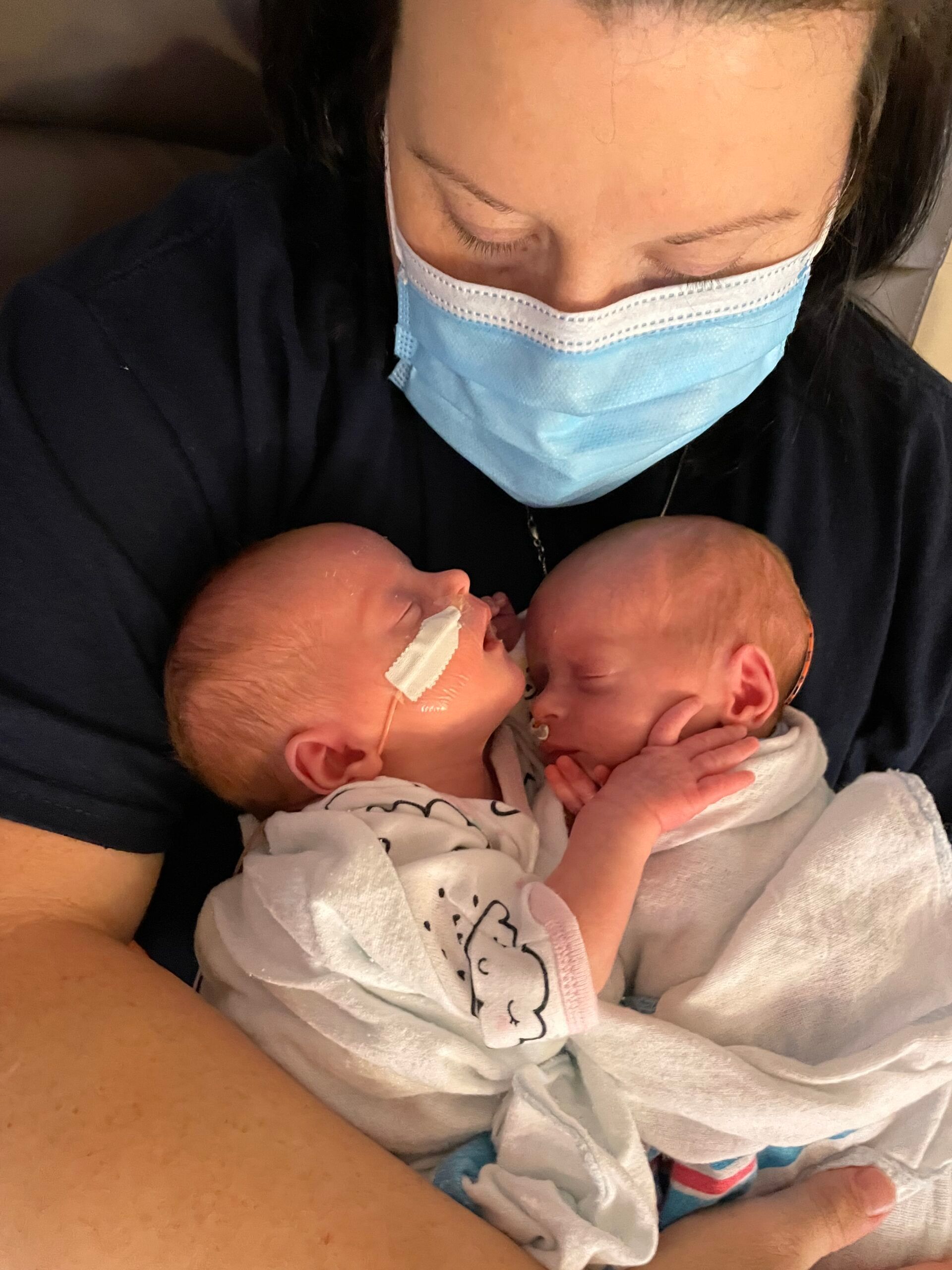 Caregiver holding two newborn babies