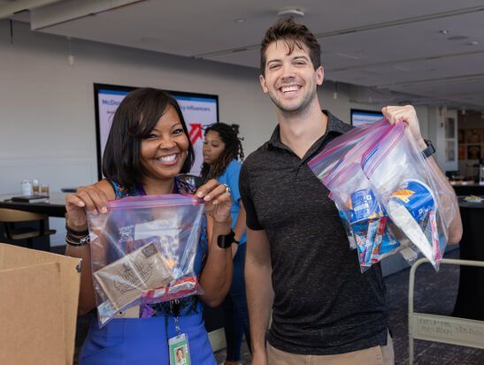 Volunteers holding care kits