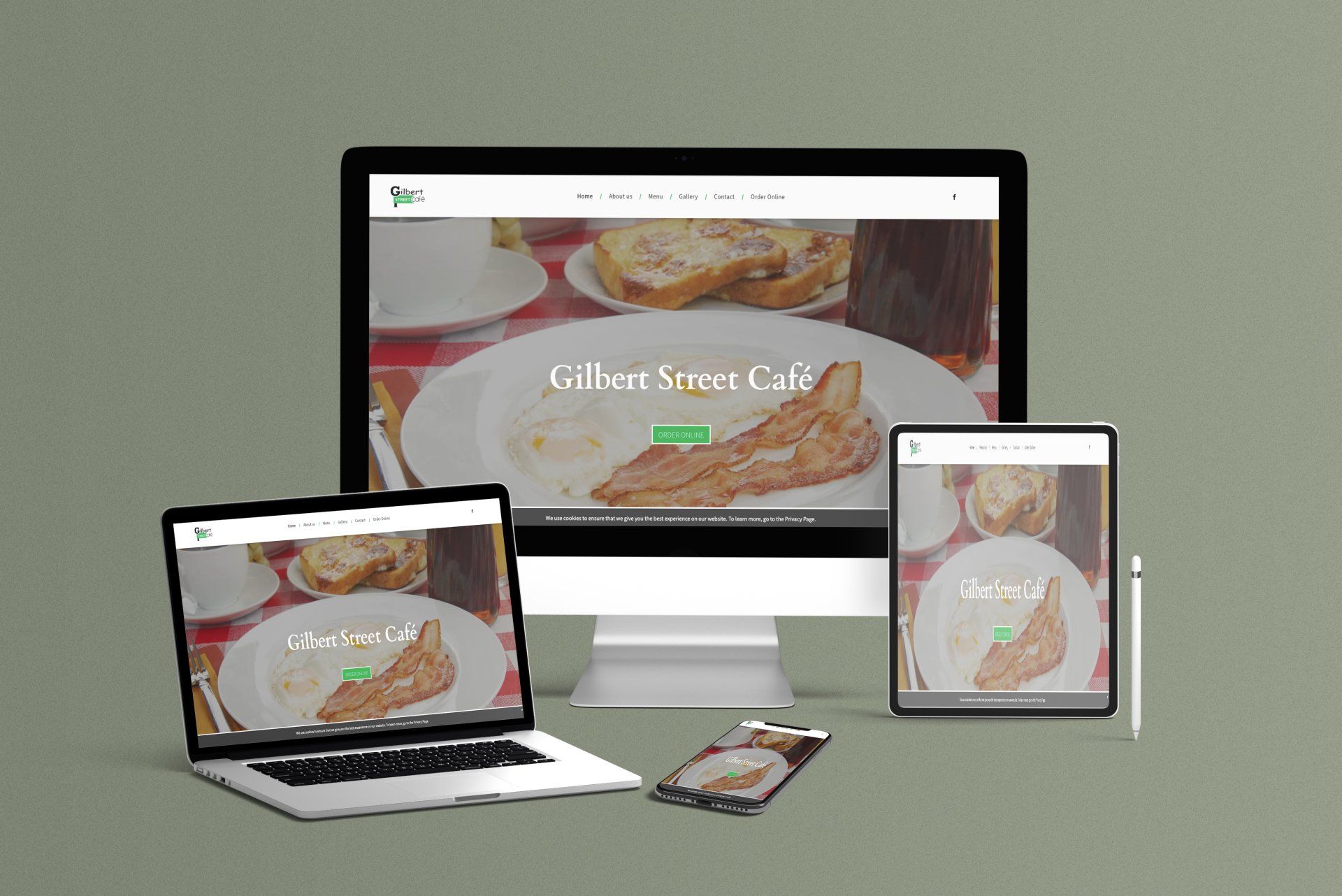 A computer , laptop , tablet , and phone are sitting on a table.