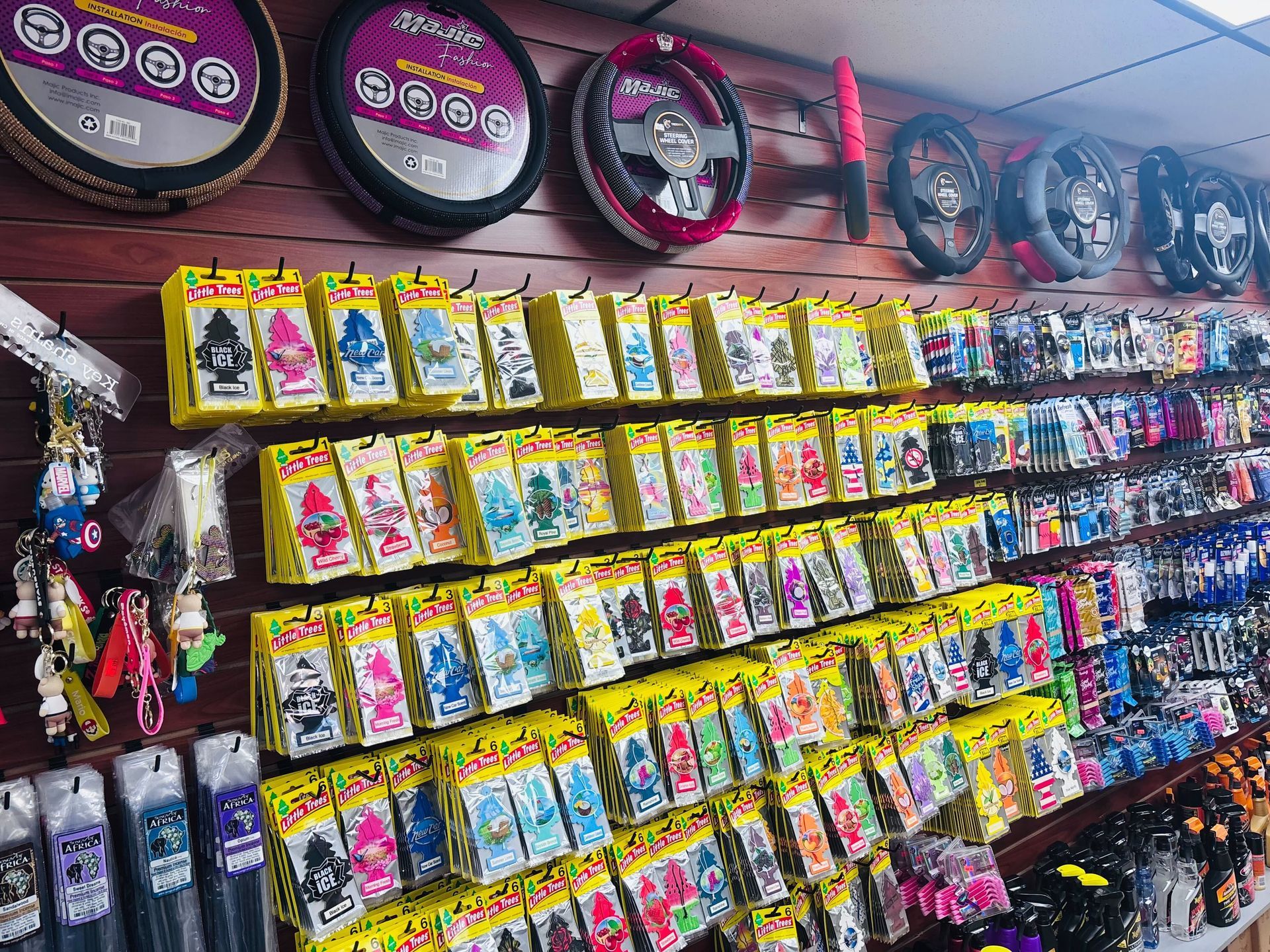 Car accessories displayed on a store wall, including steering wheel covers and air fresheners.
