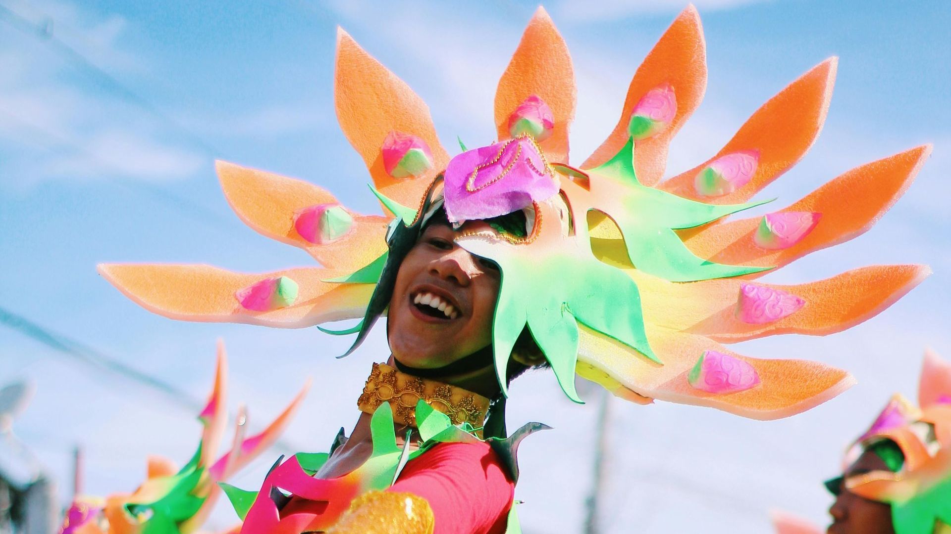 A woman in a colorful costume is smiling at the camera.