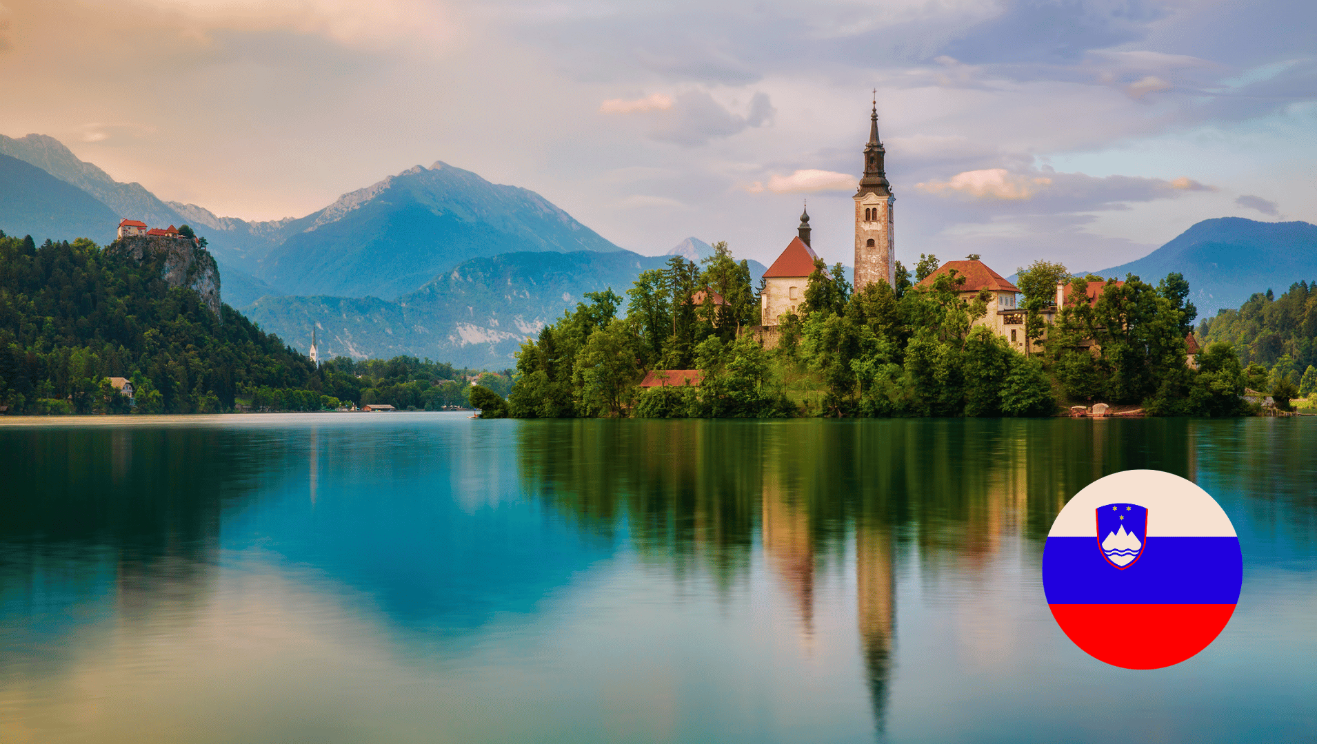 A small island in the middle of a lake with mountains in the background. Slovenia