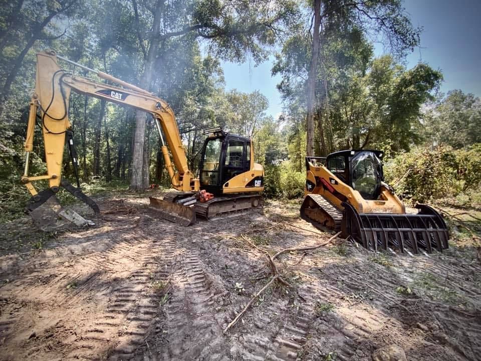 Excavator and a skid steer loader are parked next to each other in the dirt  - link to Gallery