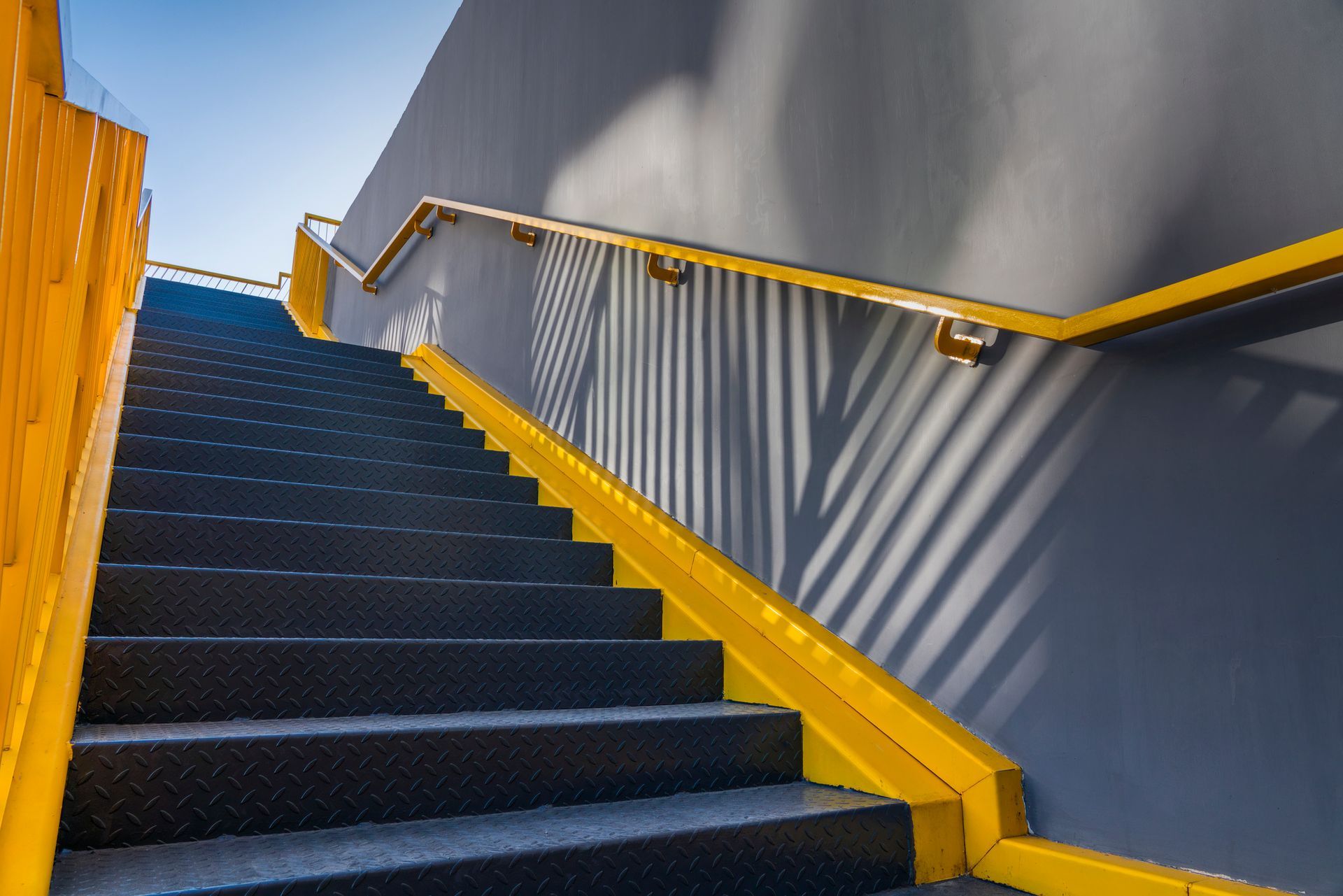 Modern yellow steel stairs in business, sourced from Steel Distributor in Helotes, TX, highlighting durability and style.]