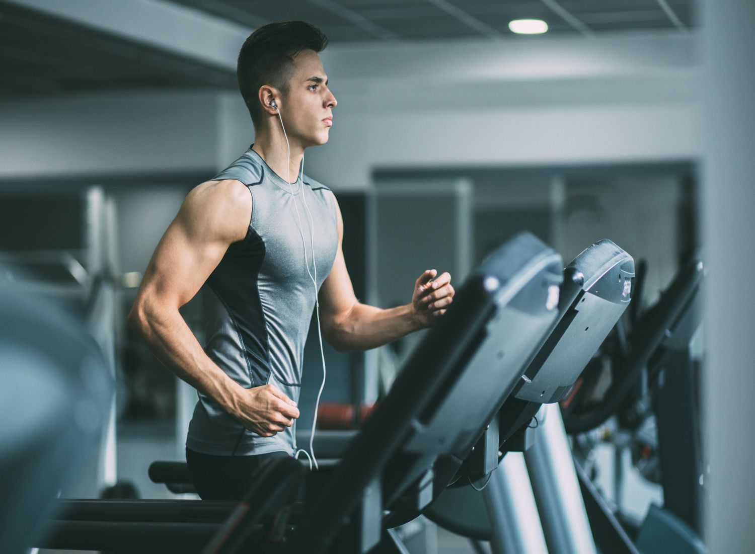 young-man-in-sportswear-running-on-treadmill-at-gym