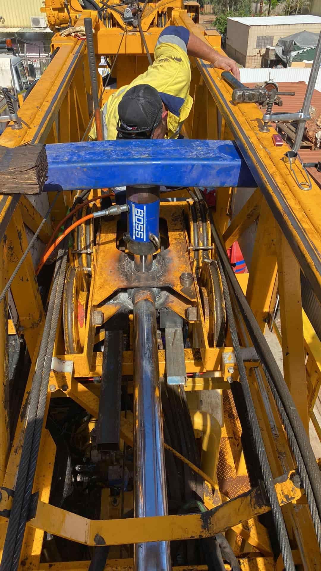 A Man is Working on a Large Yellow Machine — RK Diesel Services in Ciccone, NT