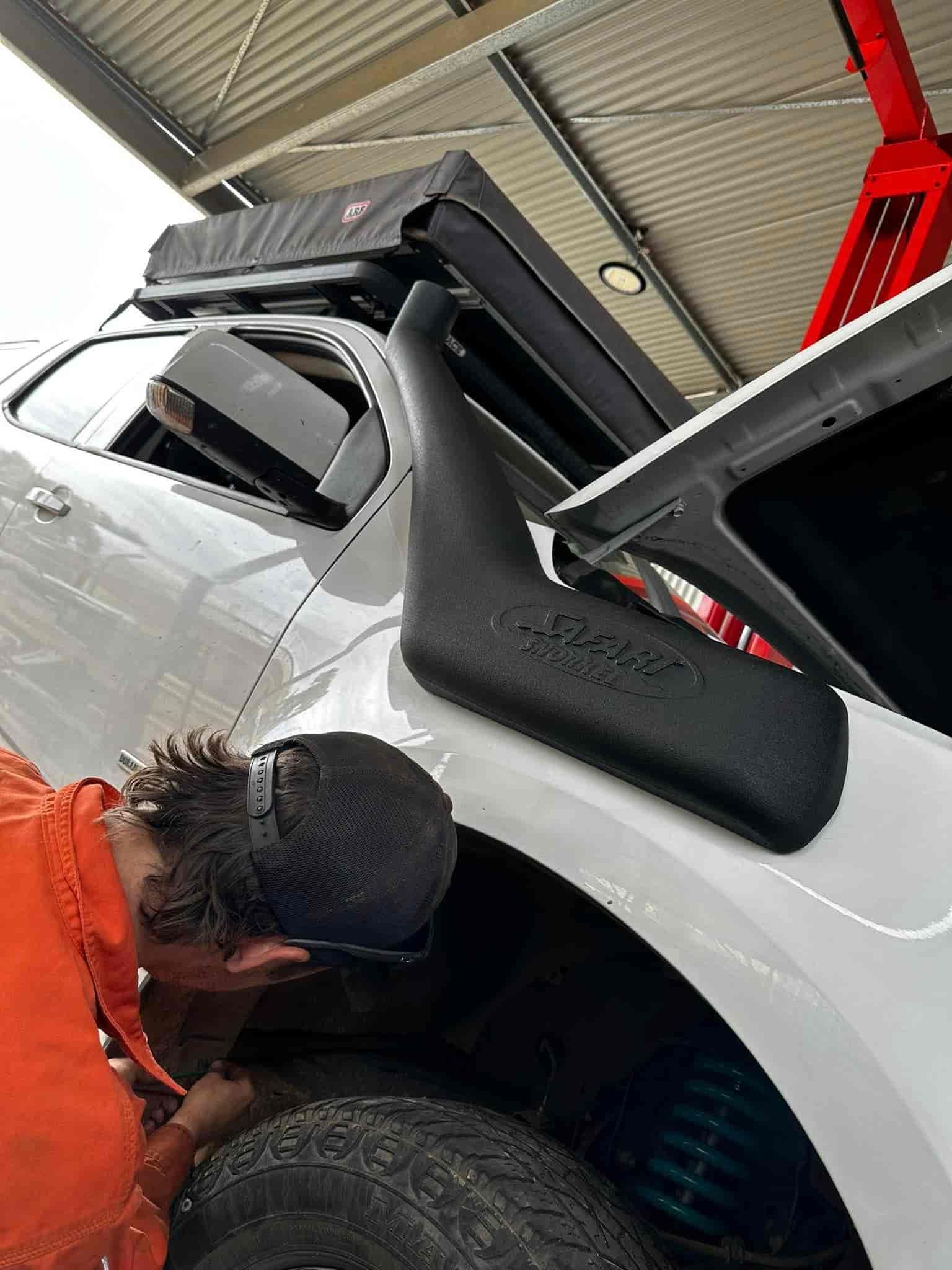 A Man is Working on a White Truck in a Garage — RK Diesel Services in Elizabeth, SA