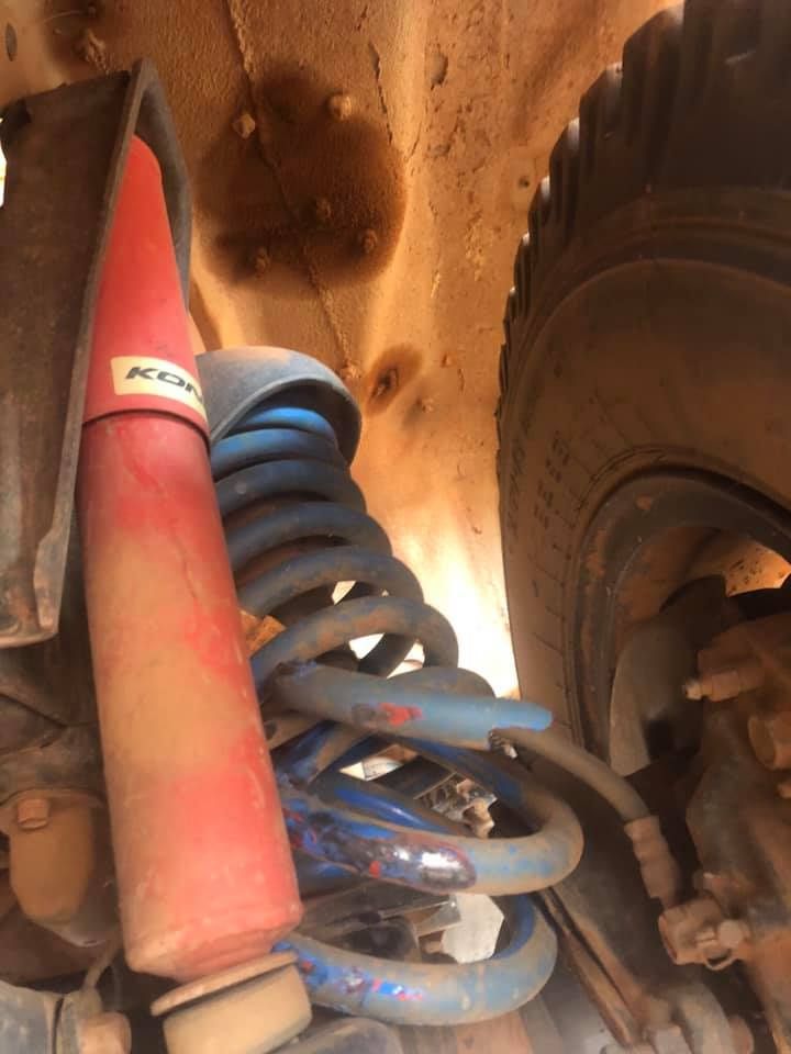 A Red Shock Absorber is Sitting Next to a Blue Coil Spring — RK Diesel Services in Salisbury, SA