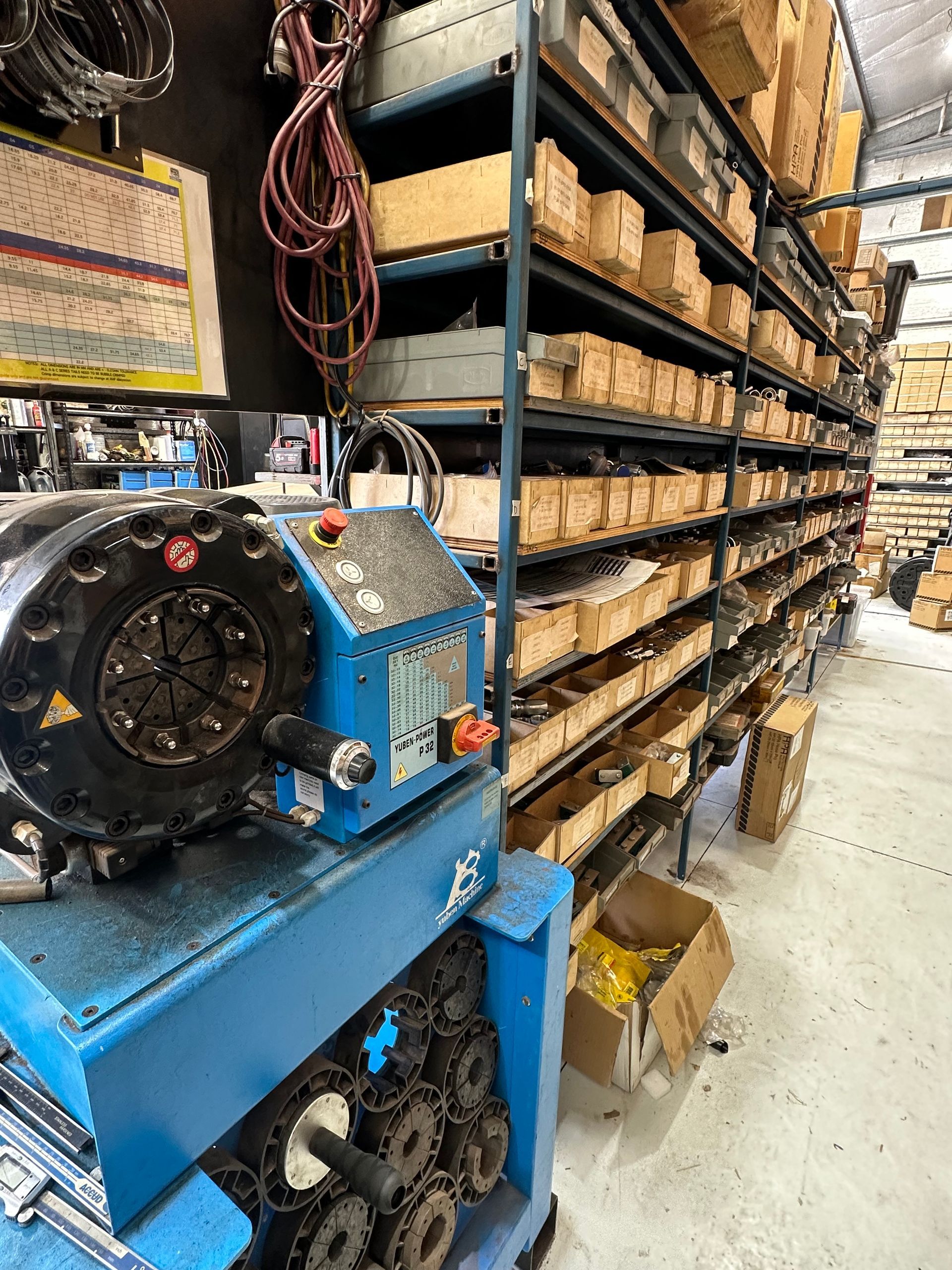 Blue industrial machine next to shelves of parts in a warehouse. — RK Diesel Services in Ciccone, NT