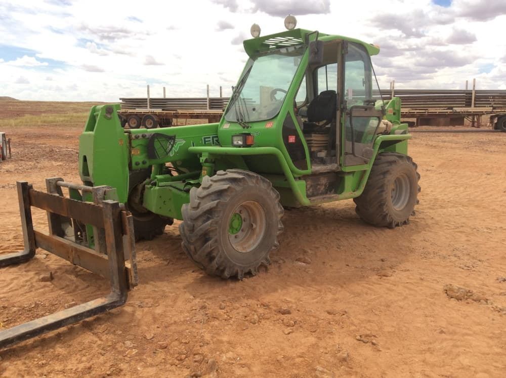 A Green Forklift is Parked in a Dirt Field — RK Diesel Services in Ciccone, NT