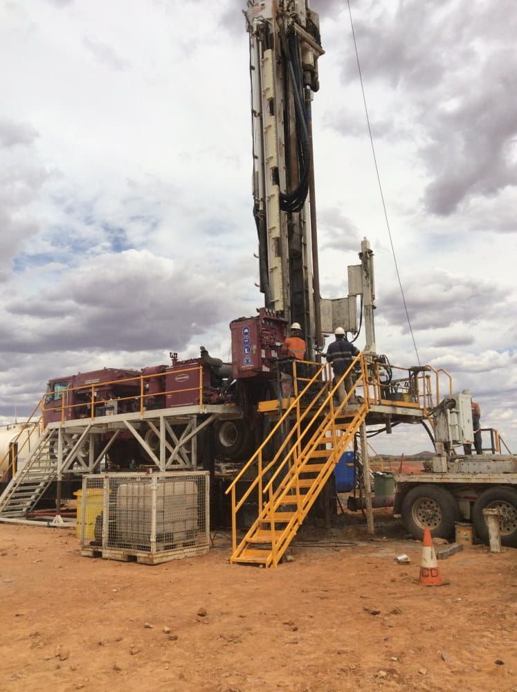 A Man is Standing on a Ladder Next to a Large Machine — RK Diesel Services in Ciccone, NT