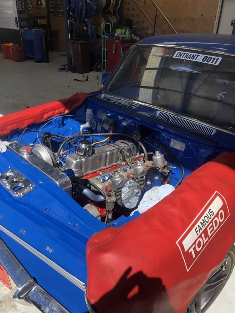 A Blue Car With a Red Cover on the Hood is Parked in a Garage — RK Diesel Services in Ciccone, NT
