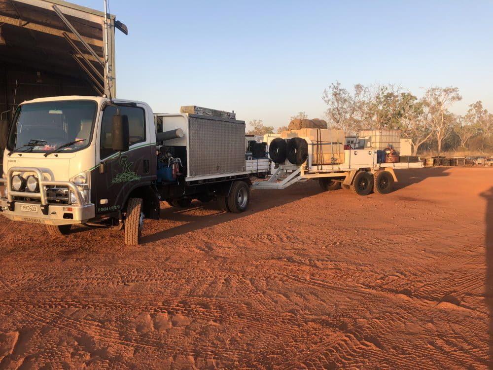 A Truck With a Trailer Attached to It is Parked in a Dirt Lot — RK Diesel Services in Ciccone, NT