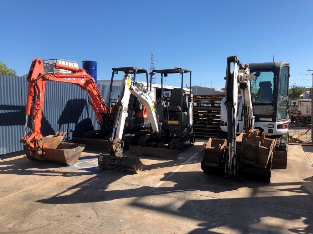 Three Excavators Are Parked Next to Each Other in a Parking Lot — RK Diesel Services in Ciccone, NT