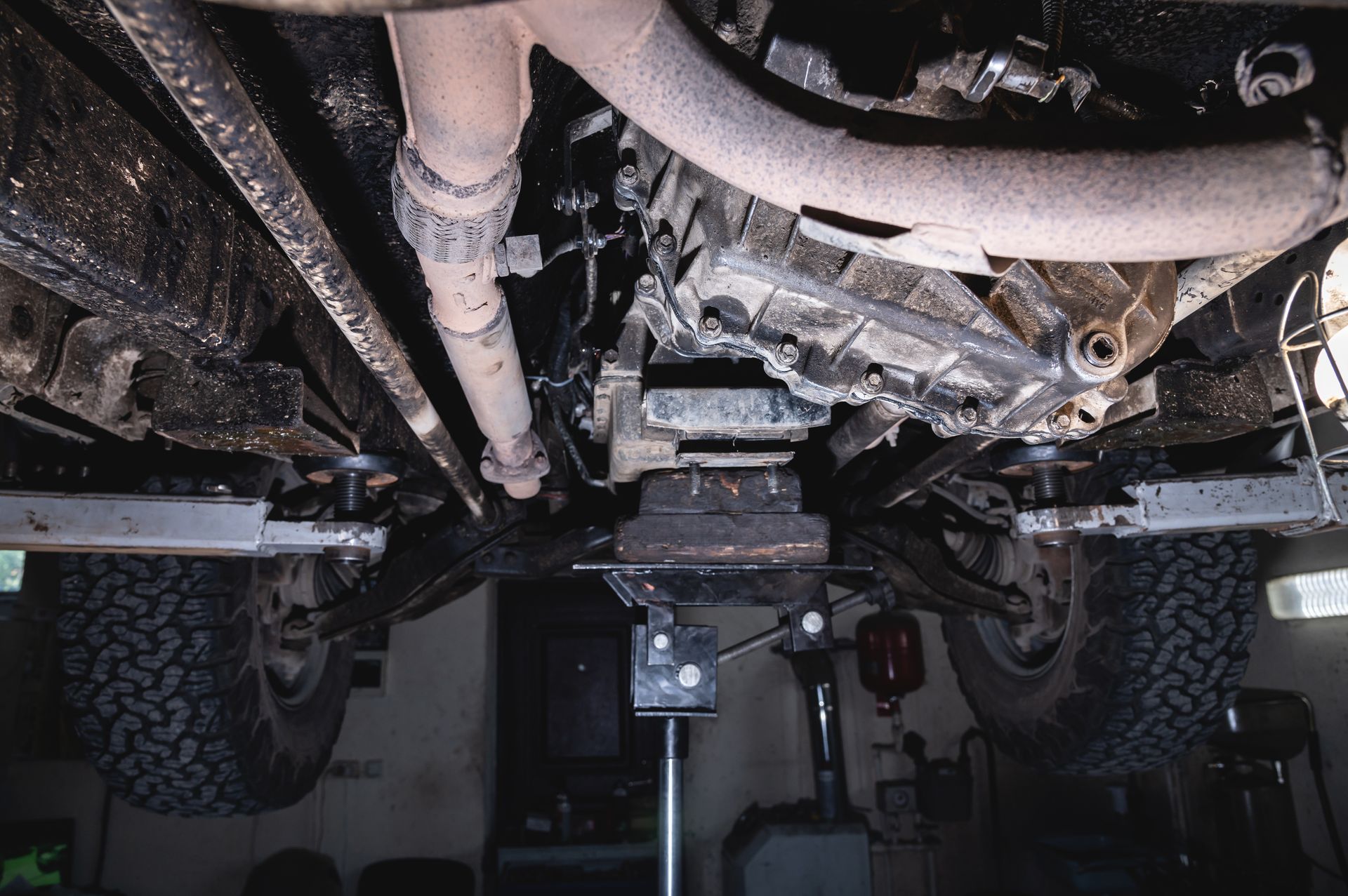 The underside of a car is shown in a garage  | Charles Automotive & Tire