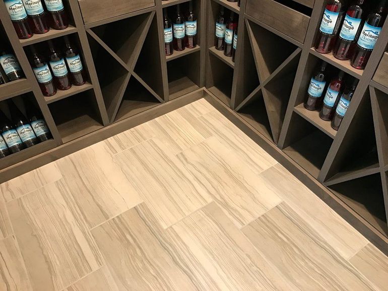 Bottles of wine are lined up on shelves in a wine cellar