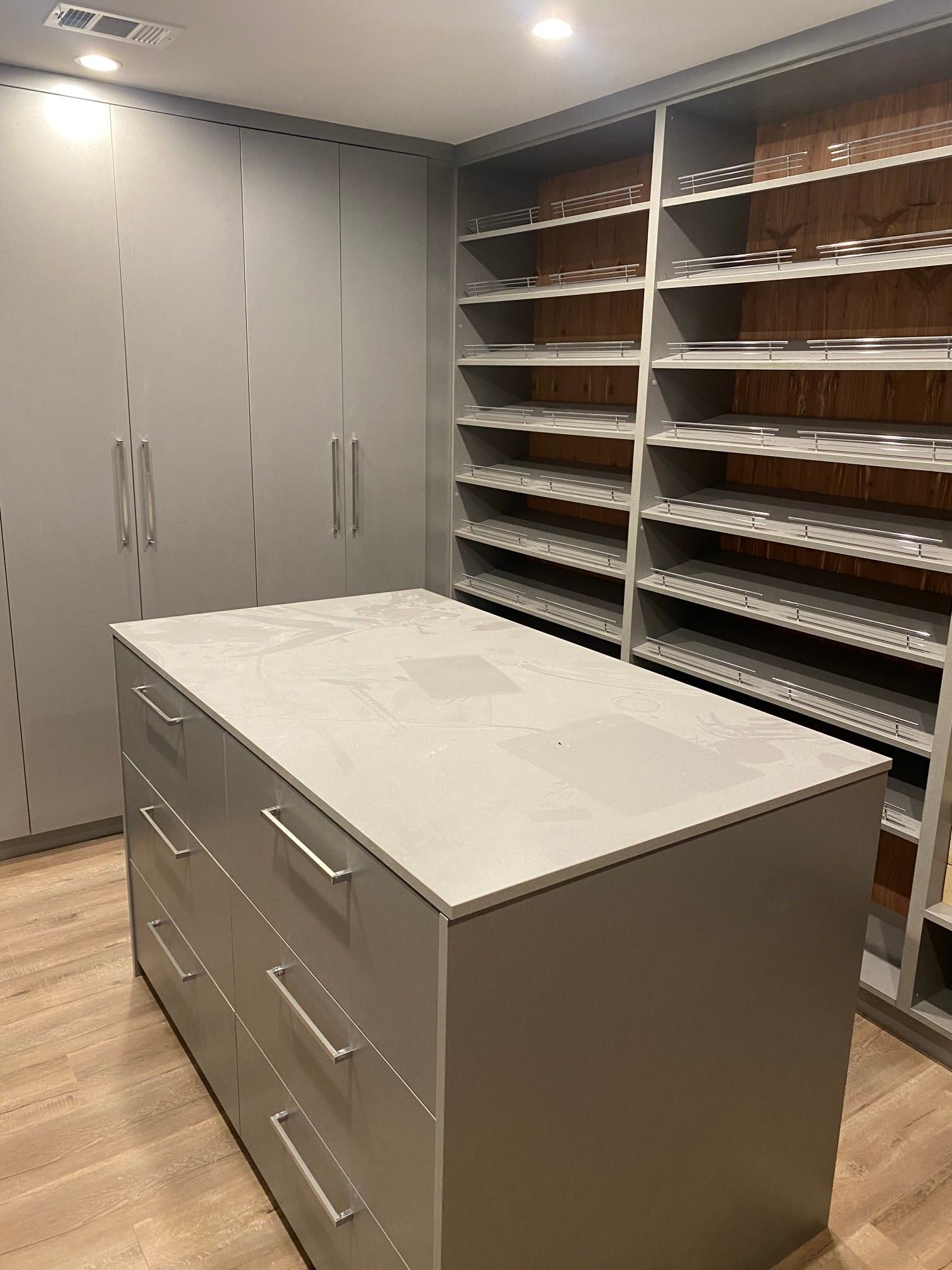 Gray walk-in closet with central island and shelves.