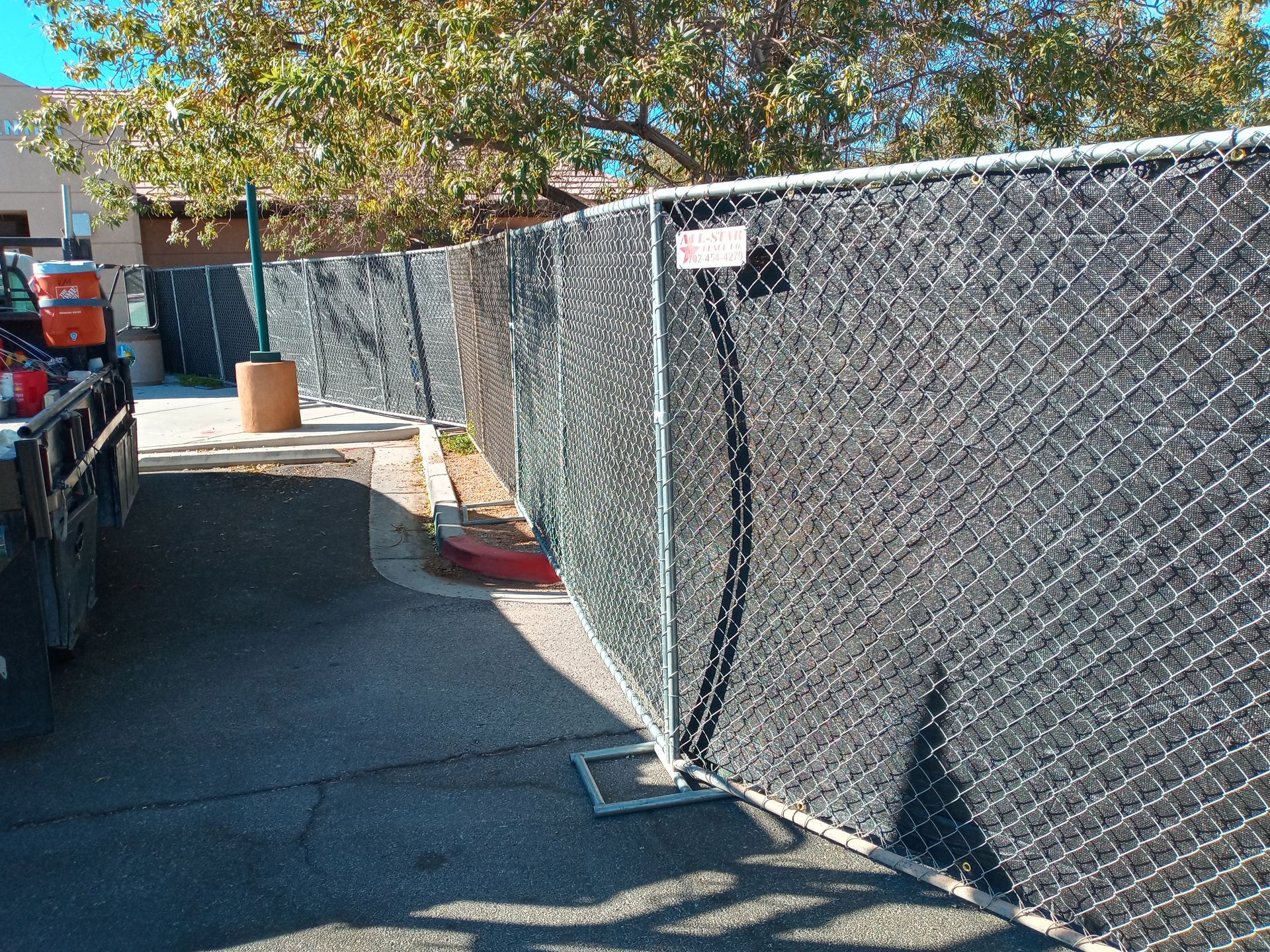 A wooden fence is in front of a house.