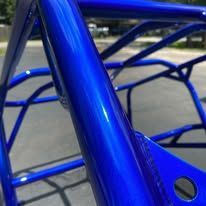 Close-up of a shiny, blue tubular metal frame with a glossy finish, likely part of a vehicle.
