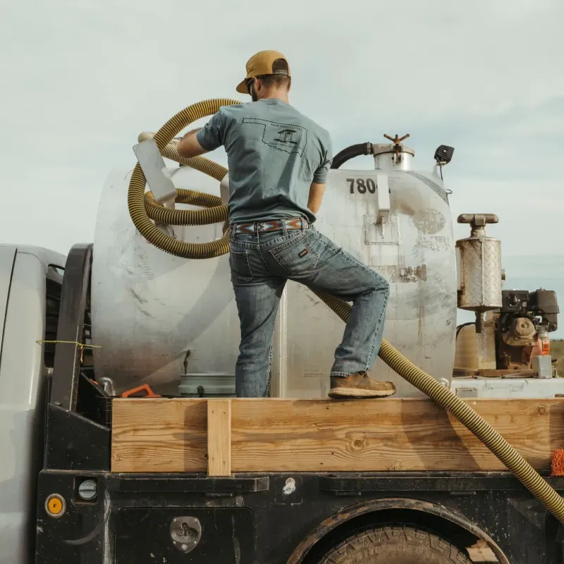A man is standing on the back of a truck with the number 780 on it