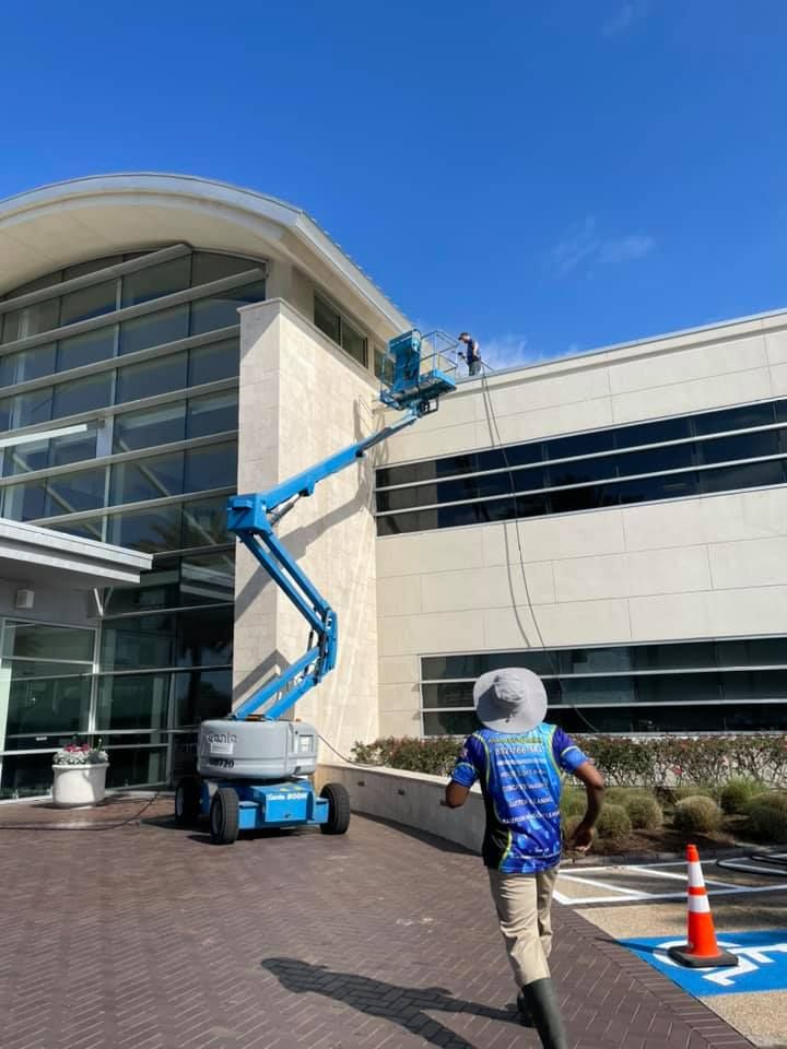 A man is walking in front of a large building with a crane in the background.