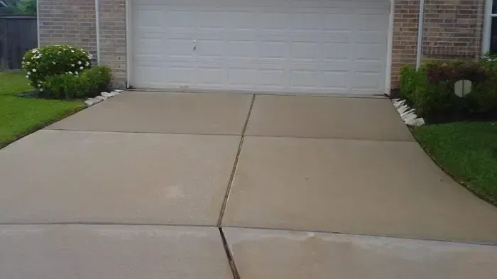 A concrete driveway leading to a garage with a white garage door.