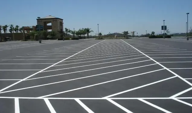 An empty parking lot with a building in the background