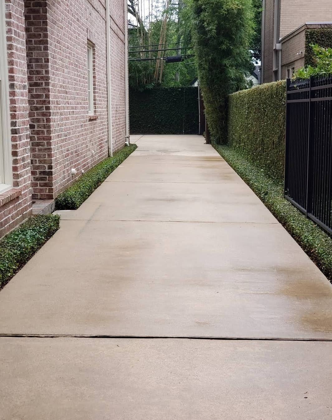 A man is cleaning a carport with a high pressure washer.
