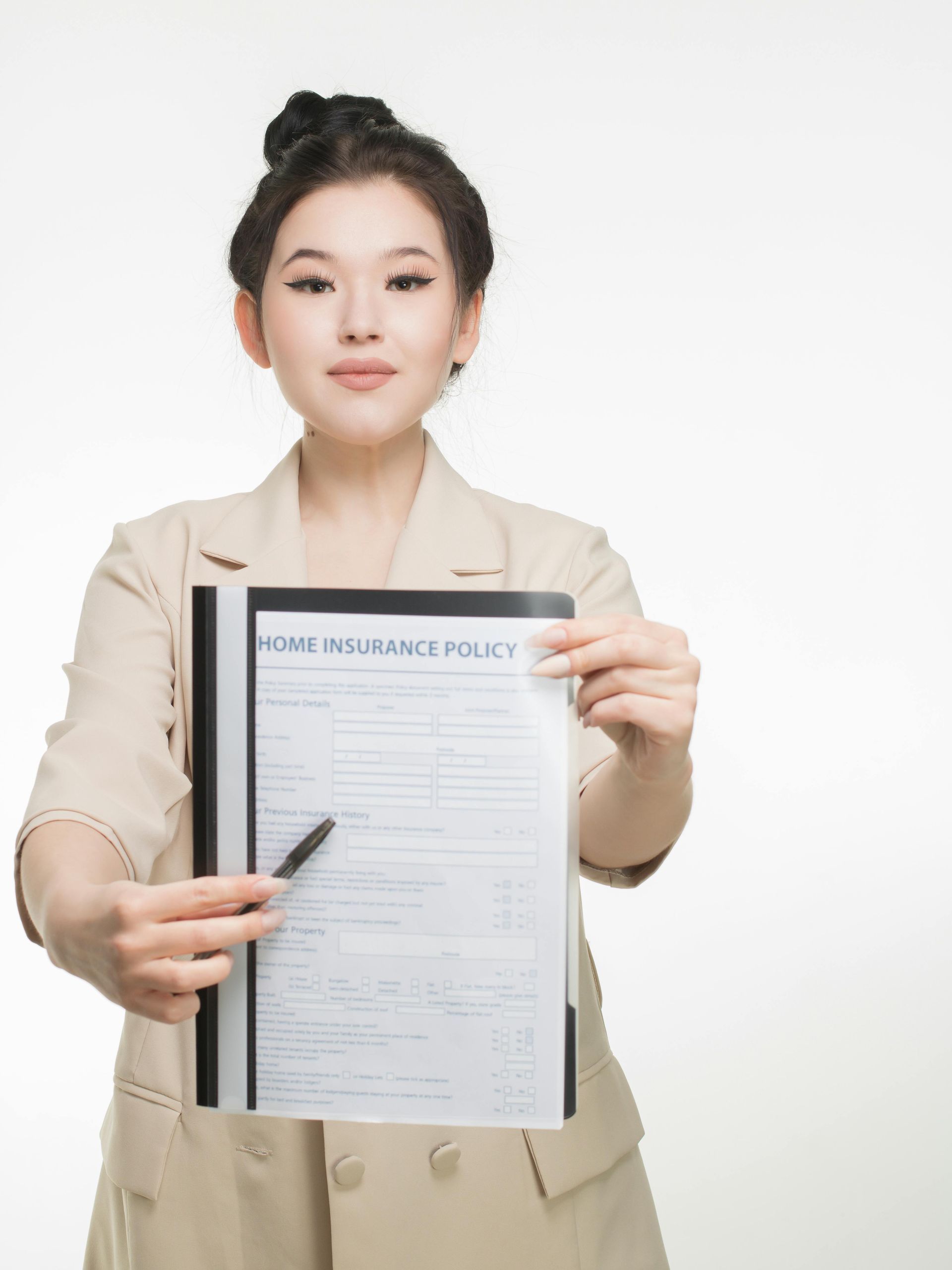 A woman is holding a piece of paper with a pen in her hand.