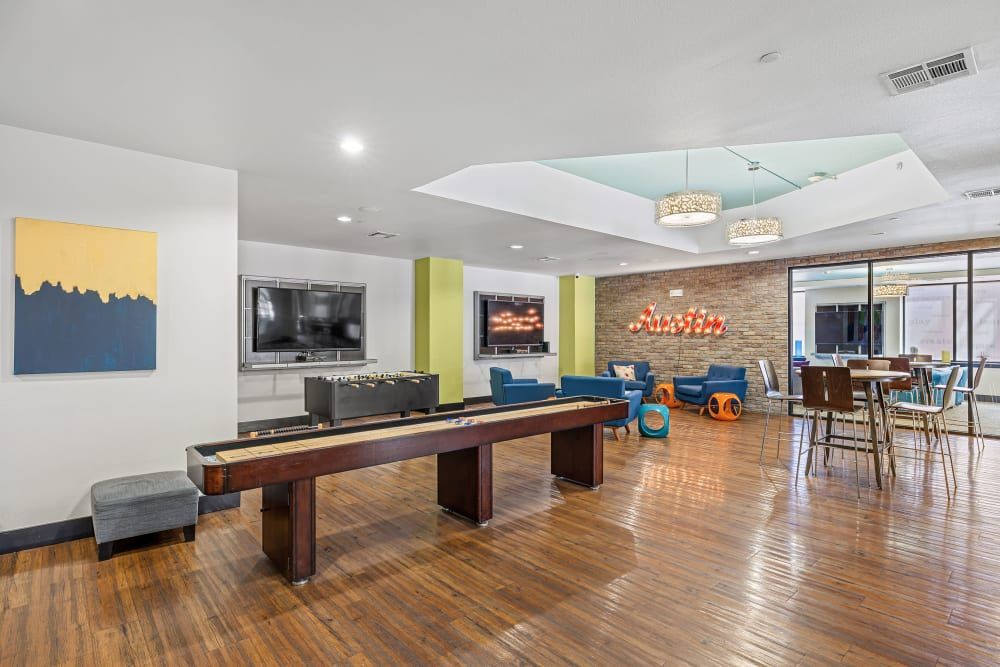 Apartment social space with shuffleboard in the clubhouse at Regents West at 24th in Austin, TX, near West Campus.